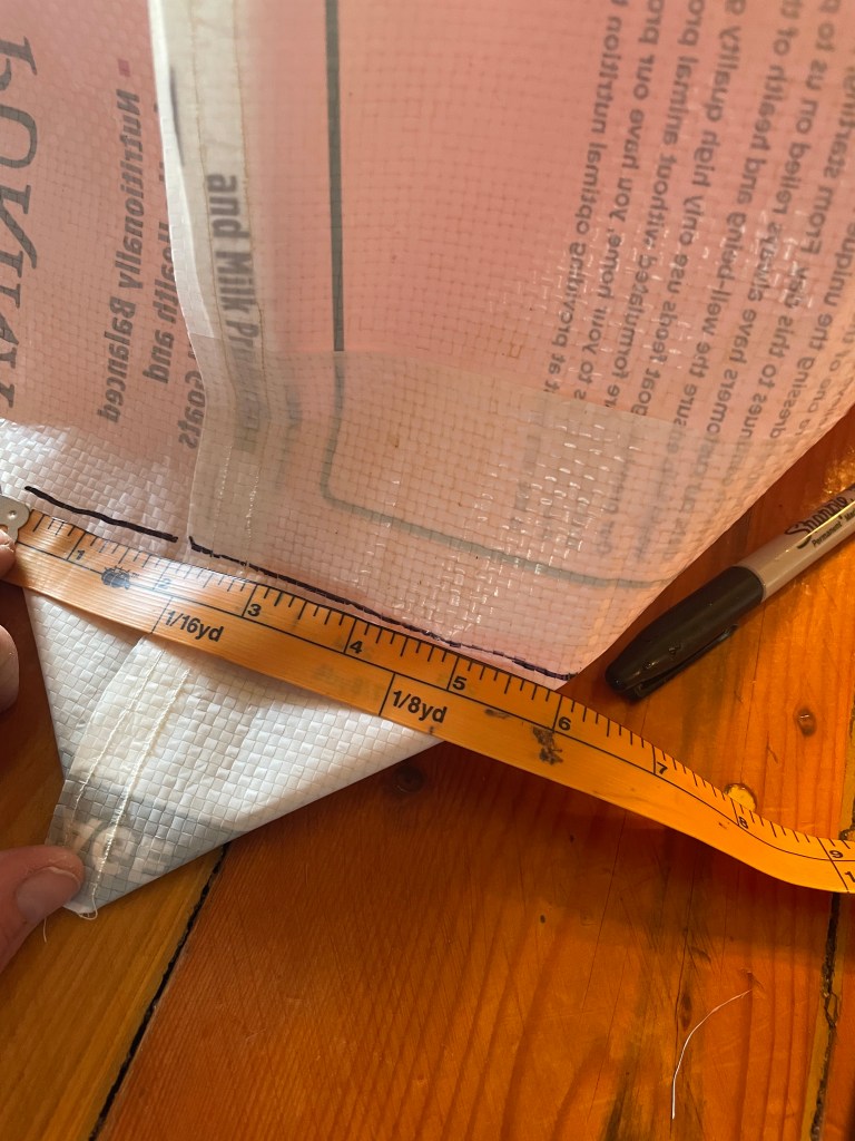 bending over the corner of the tote and measuring to match the creases, then marking with a pen 